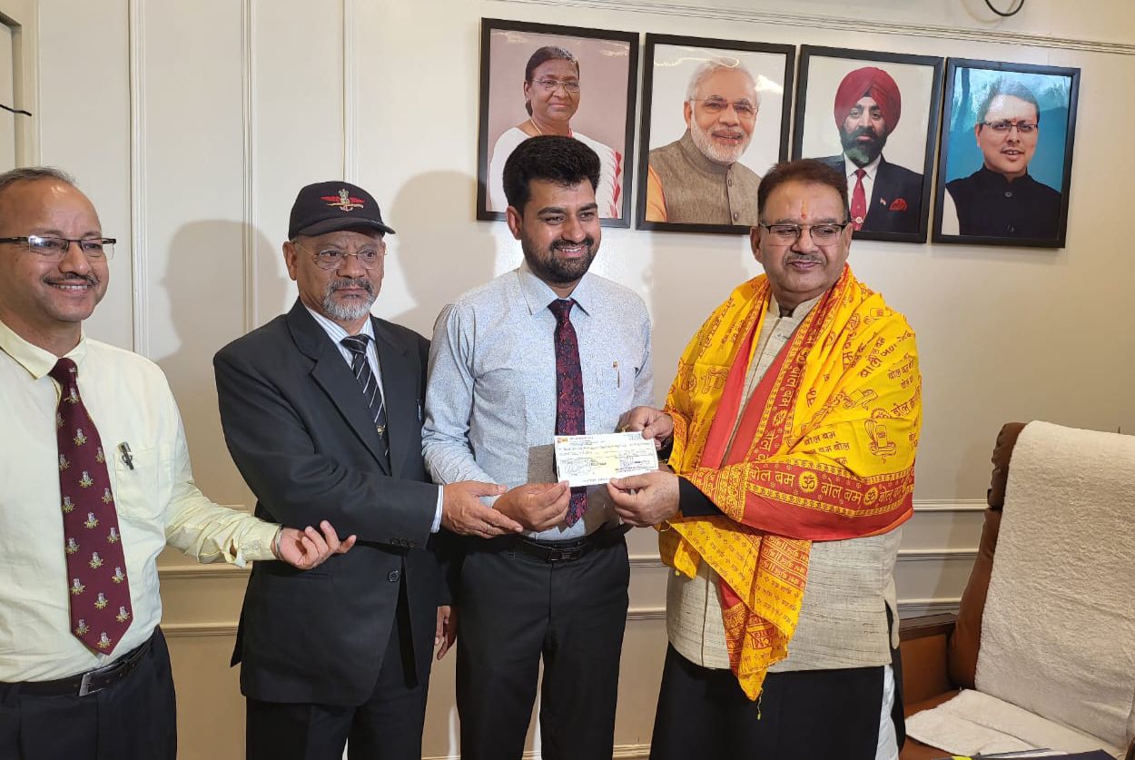 वन्दे मातरम ट्रेनिंग एण्ड एजुकेशन फाउण्डेशन के संस्थापक पूर्व सैनिक राजेश सेमवाल को 02 लाख का चेक भेंट करते सैनिक कल्याण मंत्री गणेश जोशी