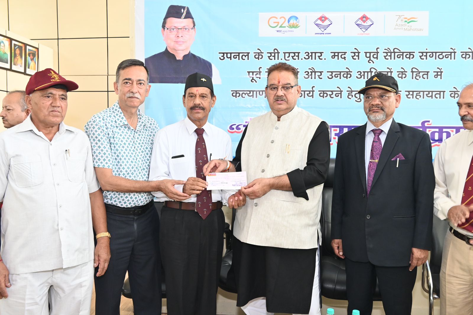 पूर्व सैनिक संगठनों के प्रतिनिधियों को आर्थिक सहायता के चैक भेट करते सैनिक कल्याण मंत्री गणेश जोशी
