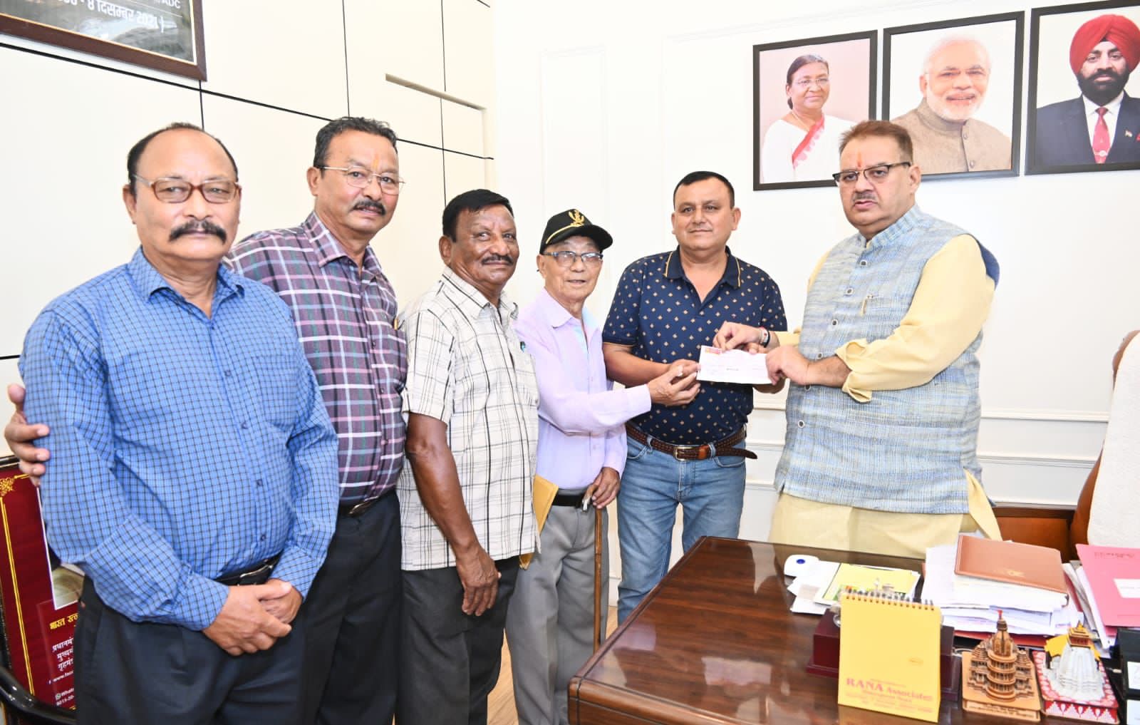आल इण्डिया गोरखा एक्ससर्विसमेन एसोसिएशन को सहायता राशि का चेक भेट करते सैनिक कल्याण मंत्री गणेश जोशी