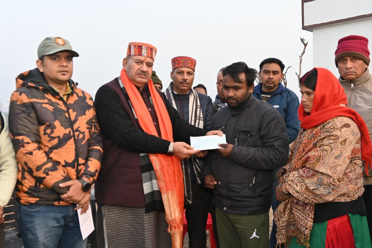 सिगली गांव में गुलदार हमले में पीड़ित परिवारजनों को मुआवजा राशि का चेक वितरित करते मंत्री गणेश जोशी