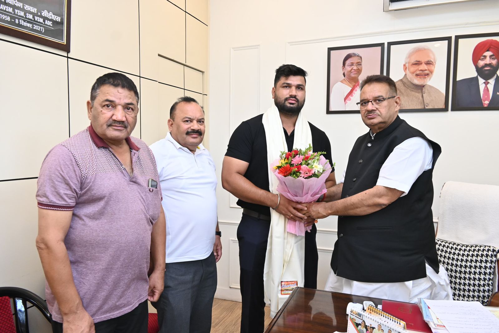 कैबिनेट मंत्री गणेश जोशी ने उनके कैंप कार्यालय में भेंट करतें वेट‌लिफ्टिर खिलाडी सूरज जोशी।