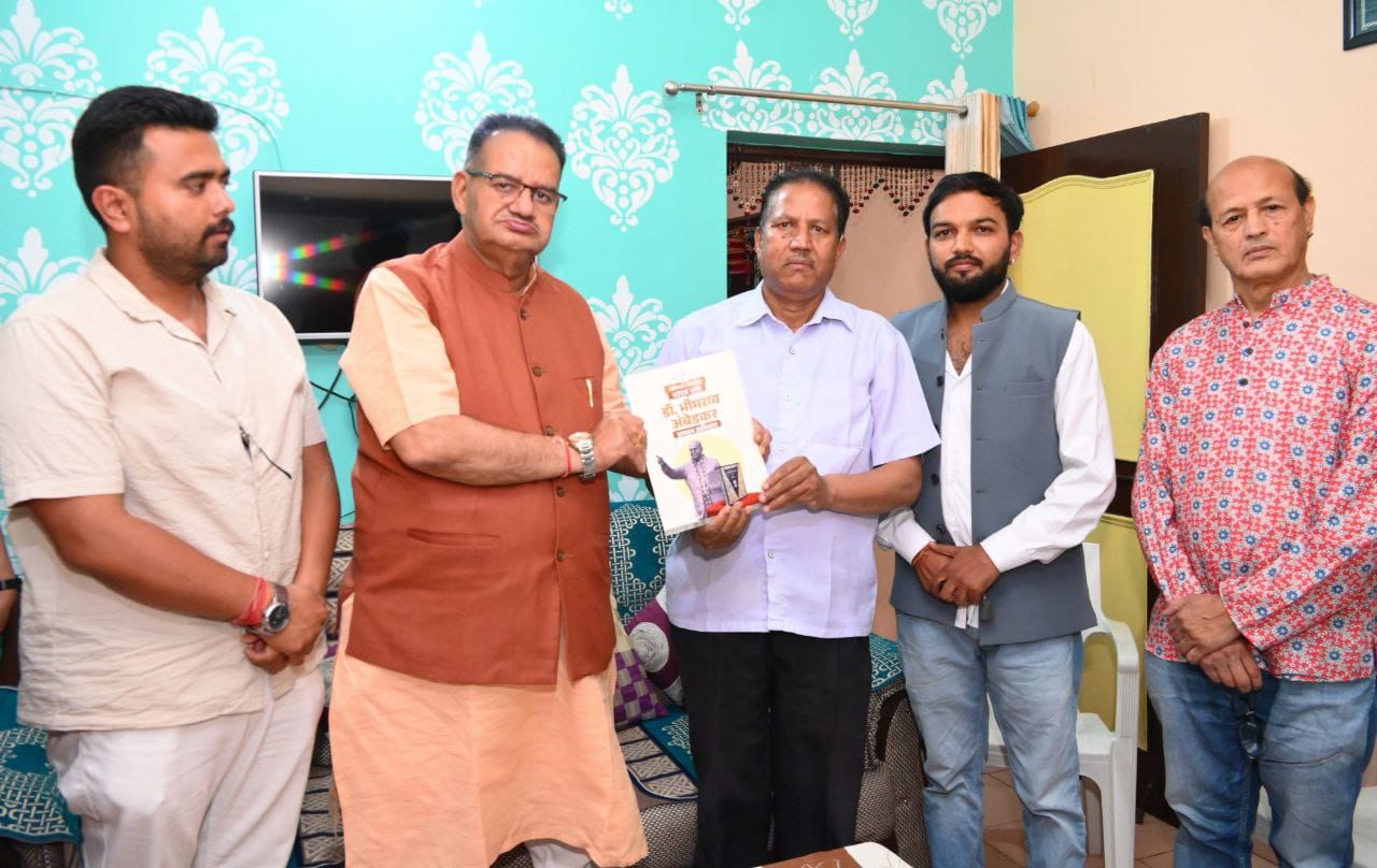 थानीगांव निवासी राजपाल सिंह को डॉ. अम्बेडकर की जीवनी भेंट करते हुए कैबिनेट मंत्री गणेश जोशी